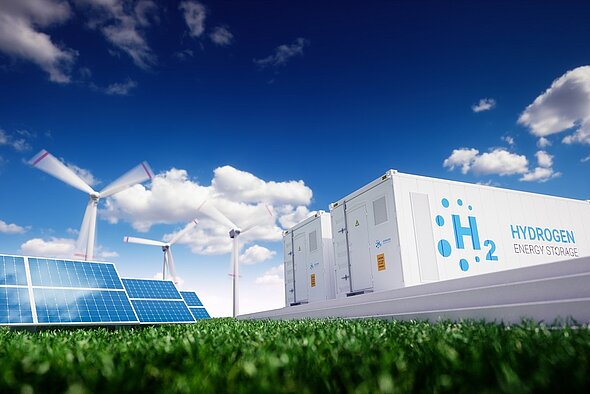 The image depicts a hydrogen energy storage facility featuring white containers labeled "H₂" and "HYDROGEN ENERGY STORAGE." In the background, wind turbines and solar panels are visible, set against a bright blue sky with clouds, symbolizing renewable energy sources.