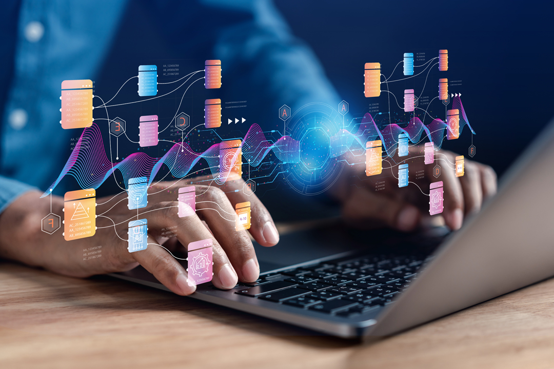 A person types on a laptop, with digital icons and data visualizations floating above the keyboard. The graphics represent data flow and connections, illustrating concepts of data management and technology interaction in a modern workspace.
