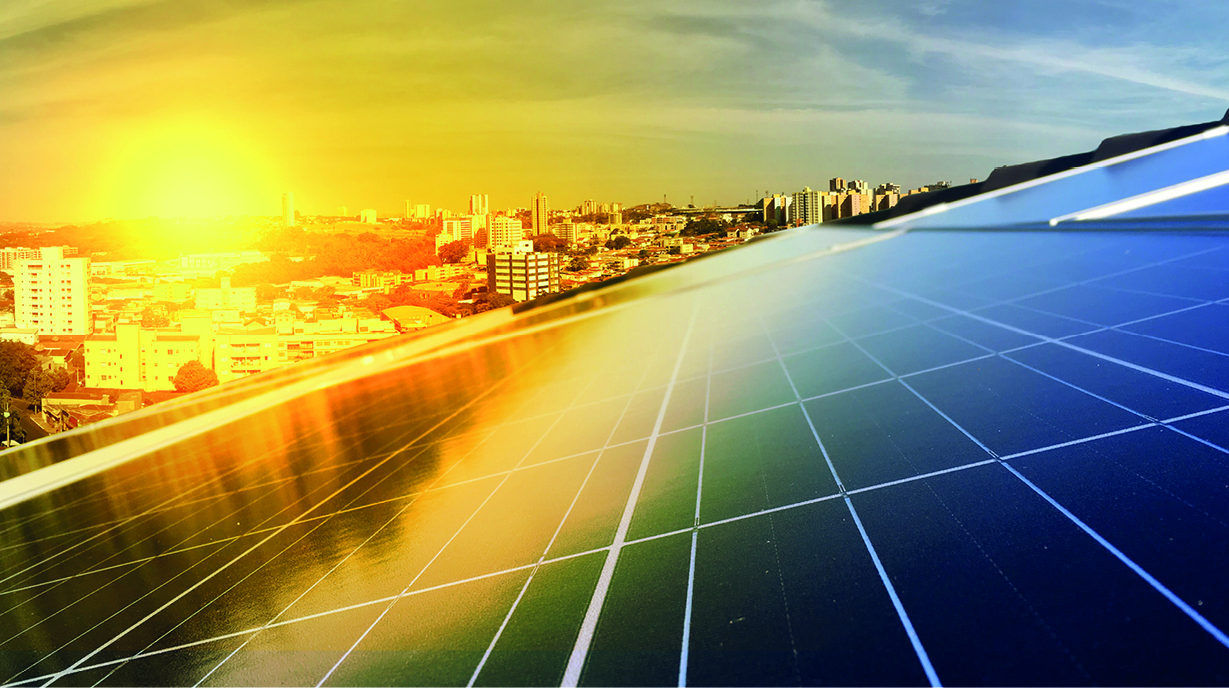 Eine Aussicht auf eine Stadtlandschaft bei Sonnenaufgang, mit einem Fokus auf Solarpanels im Vordergrund. Die Sonne strahlt am Horizont, während die städtischen Gebäude im Hintergrund sichtbar sind.