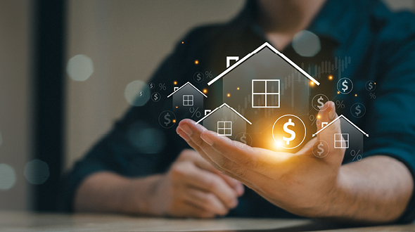 Eine Hand hält ein schwebendes Haus-Symbol mit einem Dollarzeichen. Im Hintergrund sind weitere Haus-Icons und Geldsymbole zu sehen, die finanzielle Konzepte darstellen. Die Szene vermittelt den Eindruck von Immobilienwert und Investitionen.