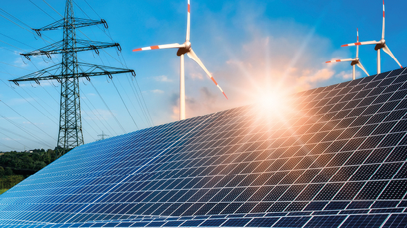 A sunny landscape featuring a large array of solar panels in the foreground. In the background, wind turbines are visible, contributing to renewable energy. The scene portrays a harmonious blend of solar and wind energy sources under a clear blue sky.