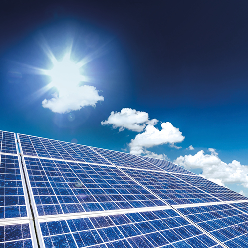 Ein Solarpanel wird von Sonnenlicht bestrahlt, das hell am Himmel scheint. Im Hintergrund sind einige Wolken sichtbar. Die Darstellung verdeutlicht die Nutzung erneuerbarer Energien durch Solarenergie.
