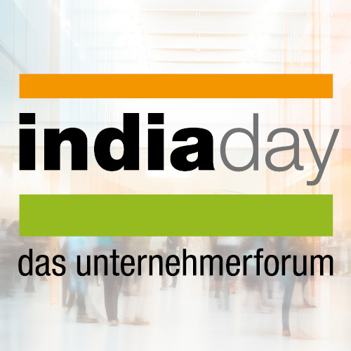 Logo von "India Day – das Unternehmerforum" mit orangefarbenem, grünem und schwarzem Text auf einem verschwommenen Hintergrund, der eine Veranstaltung oder ein Forum darstellt.