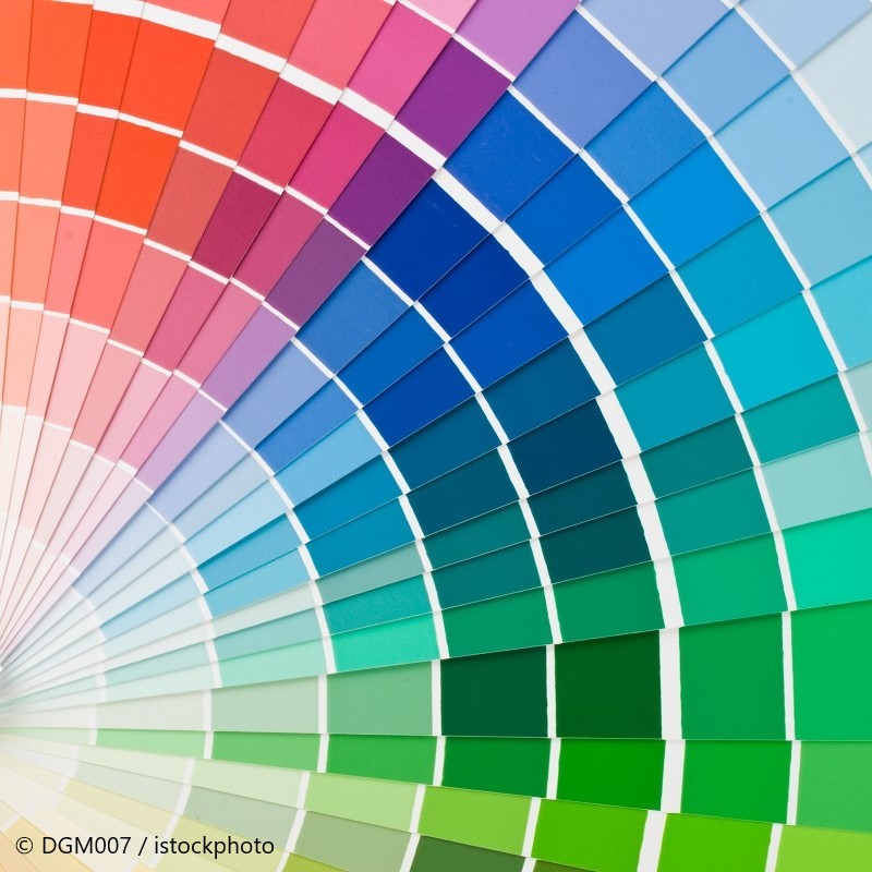 Eine Farbpalette mit mehreren Farbkarten, die in einem halbkreisförmigen Muster angeordnet sind. Die Farben reichen von Rot über Lila und Blau bis zu verschiedenen Grüntönen, die sanft ineinander übergehen und eine breite Palette an Farbnuancen darstellen.