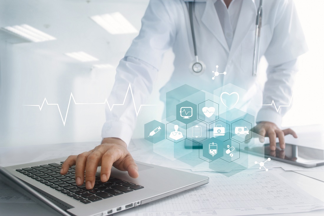 Ein Arzt in weißem Kittel arbeitet an einem Laptop. Vor ihm schwebt eine grafische Darstellung mit verschiedenen medizinischen Symbolen, die digitale Gesundheitsdienste und Technologien repräsentieren. Im Hintergrund ist ein pulsierender Herzschlag zu sehen.
