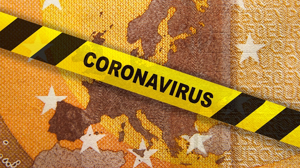 Ein gelbes Warnband mit der Aufschrift "CORONAVIRUS" liegt über einer abstrakten Darstellung von Europa, die aus verschiedenen Geldnoten erstellt zu sein scheint. Das Bild vermittelt die Verbindung zwischen der COVID-19-Pandemie und wirtschaftlichen Auswirkungen.