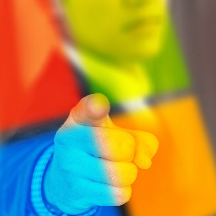 Ein gehobenes Handzeichen zeigt mit dem Zeigefinger nach vorne. Der Hintergrund ist in leuchtenden, bunten Farben gehalten, die eine energetische Atmosphäre schaffen. Die Geste kann Entschlossenheit oder Einladung symbolisieren.