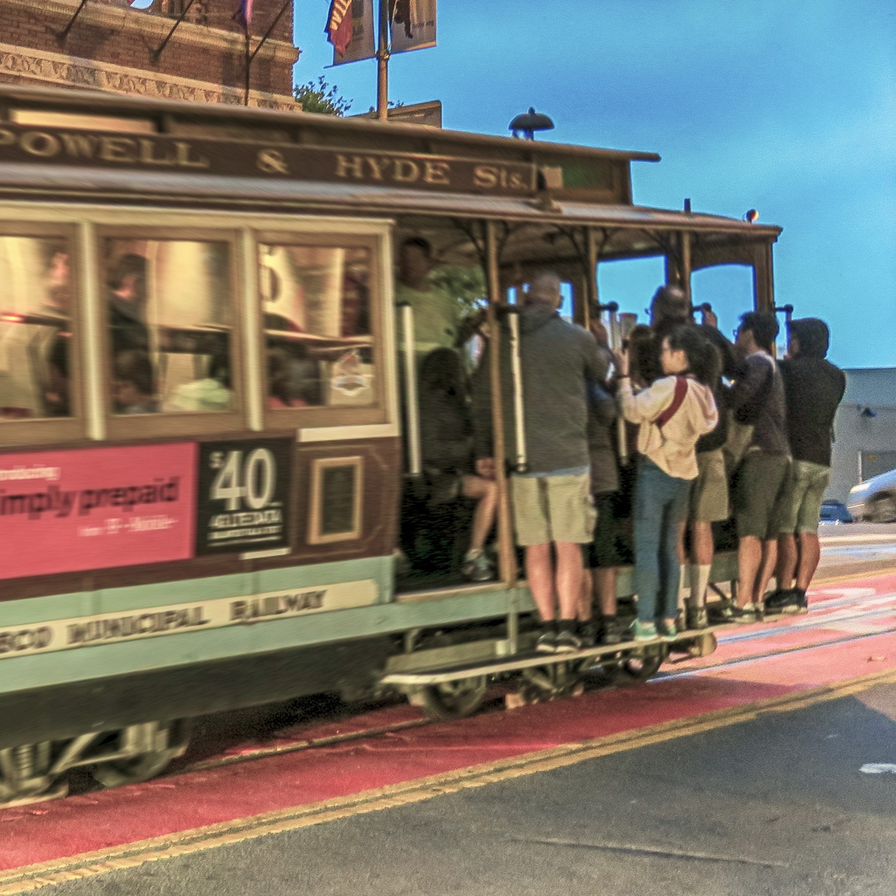 Eine historische Straßenbahn hält an einer Haltestelle. Mehrere Passagiere stehen auf der Plattform und halten sich an den Stangen fest. Die Atmosphäre wirkt lebhaft und urban, bei gedämpftem Licht. Es ist offensichtlich, dass die Straßenbahn ein beliebtes Fortbewegungsmittel ist.